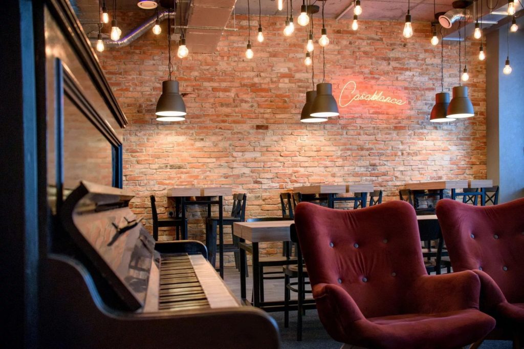 Relaxation area at Rise.pl Galileo featuring an armchair and a piano