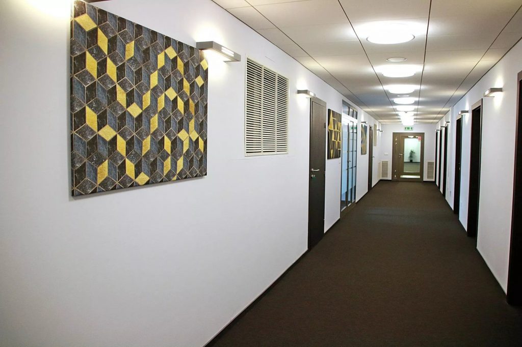 Hallway at Biznes Zone Cracow featuring some gray, black and yellow coloured wall art